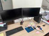 two computer monitors sitting on a desk with a keyboard and mouse