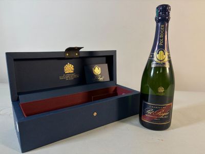 une bouteille de champagne à côté d'un coffret sur une table
