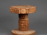 a small wooden table with carvings on top of it