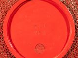 a red vase with a red lid sitting on a table