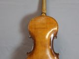 an old violin sitting on top of a table next to a wall