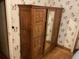 a wooden armoire with a mirror on top of it