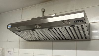 a kitchen with a stove, refrigerator, and a range hood