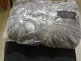 une chaise noire sur laquelle est posé un sac en plastique