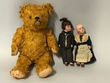 deux poupées et un ours en peluche assis les uns à côté des autres
