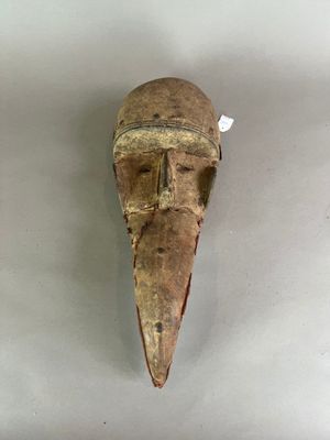 gros plan d'un masque en bois sur une surface blanche