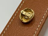 leather belt with a gold buckle on a white surface