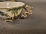 a small bowl with a bird on it sitting on a table