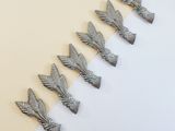 six silver metal birds on a white and yellow background