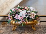 a gold vase with flowers in it on a marble table
