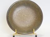 a brown plate on a gold stand on a white background