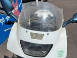 une moto garée devant un immeuble, sur un parking