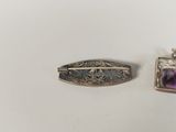 pair of silver and amethoral brooches with purple stones