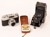 three different types of cameras on a white surface