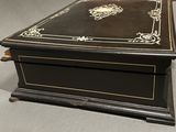 a black box with gold trim on it sitting on a table