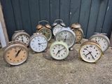 de nombreuses horloges posées par terre devant une porte