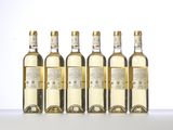 six bottles of white wine are lined up on a table