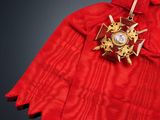 a red cloak with a gold cross and a star on it