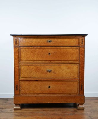 une commode en bois posée sur un parquet