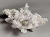 some white crystals on a white surface with a black object in the background
