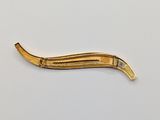 an image of a gold colored hair clip on a white surface