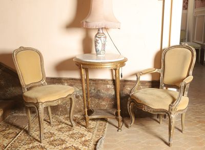 two chairs and a table with a lamp on top of it