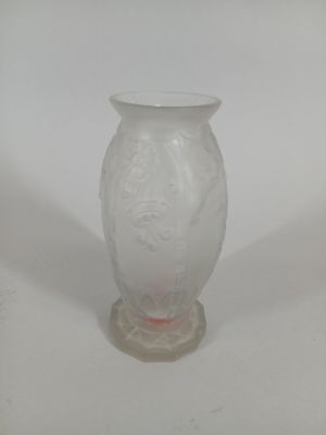 a white vase with a red handle on a white table