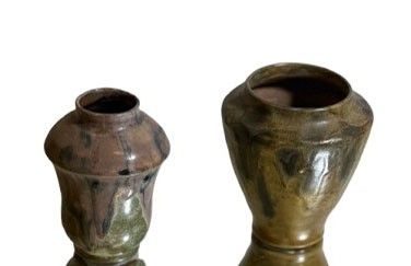 deux vases posés l'un à côté de l'autre sur une surface blanche