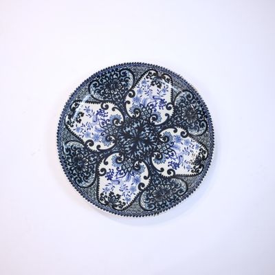une assiette bleue et blanche ornée d'un motif floral