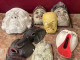 de nombreux masques posés sur une table avec un fond rouge