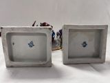 pair of white porcelain vases with blue flowers on them sitting on a table