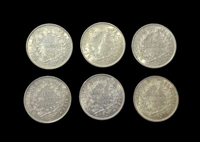 six different british coins on a black background