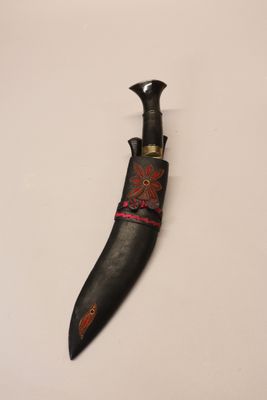 a close up of a knife on a table with a white background