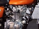 an orange motorcycle parked in a garage with a white wall in the background