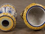 two vases that are sitting on a tile floor
