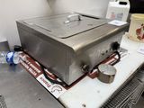 a large stainless steel pan sitting on top of a table