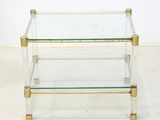 a glass and brass coffee table with three shelves