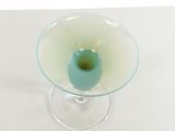 a glass vase that has a blue candle inside of it