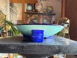 a blue bowl sitting on top of a black table