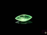 a close up of a green diamond on a black surface