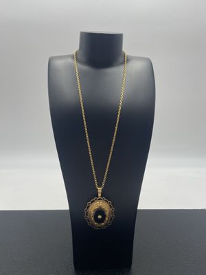 un mannequin noir portant un collier en or