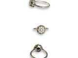 three silver rings and a diamond ring on a white background