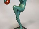 statue d'un homme tenant une balle dans la main, posée sur un socle en marbre