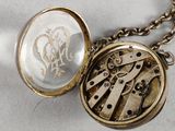 a close up of a necklace with a clock inside of it