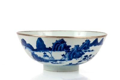 un bol bleu et blanc posé sur une surface blanche