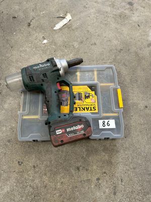 a cordless drill on the ground next to a tool box