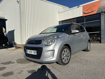 La petite voiture est garée devant un grand immeuble.