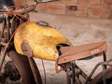 an old motorcycle with a helmet on the back of it