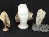 cinq chapeaux sur une tête de mannequin et un chapeau sur une tête de mannequin