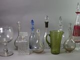 many different types of glass bottles and vases on the table